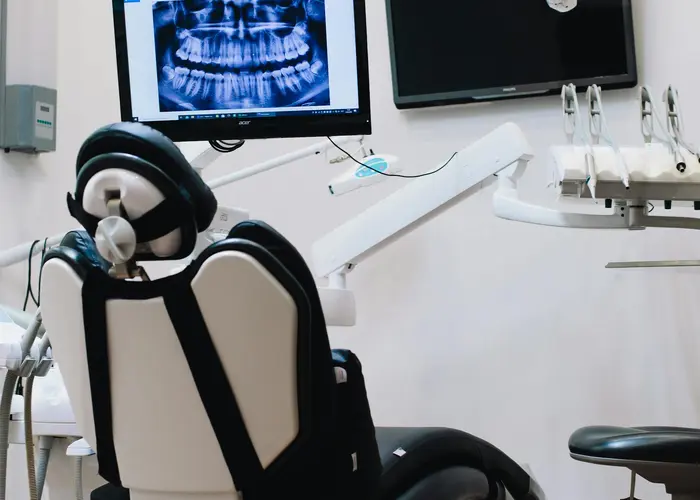 A modern dental surgery with a chair and a panoramic dental X-ray on screen