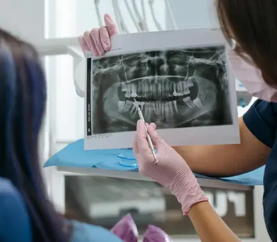 A dentist explaining a panoramic dental X-ray to a patient