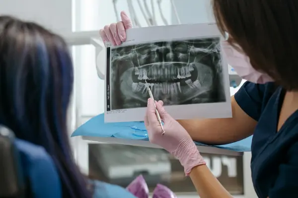 A dentist explaining a panoramic dental X-ray to a patient