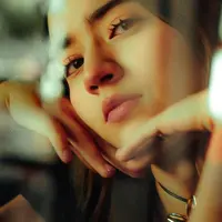 A woman resting her chin on her hands, thinking something over