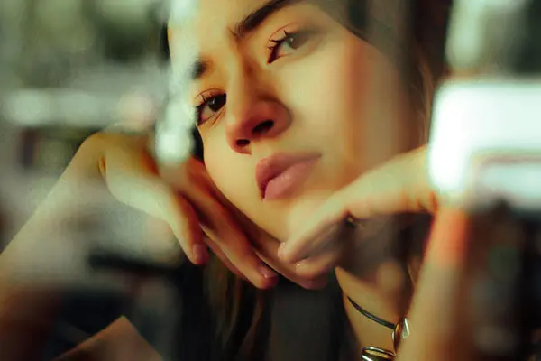 A woman resting her chin on her hands, thinking something over